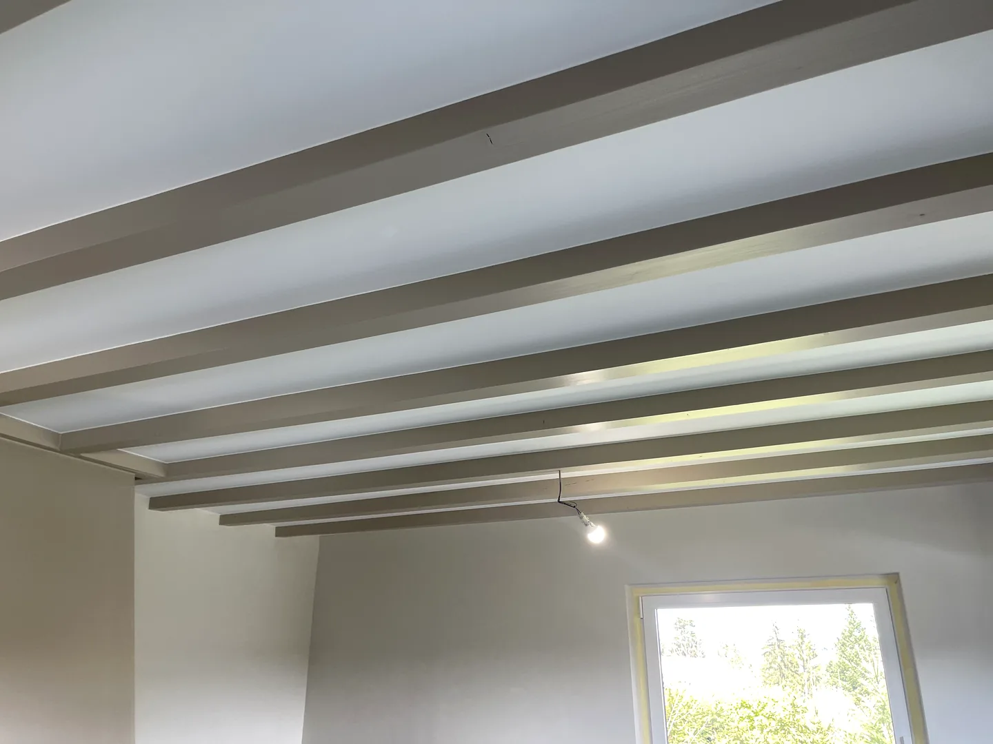 Plafond rénové avec poutres apparentes peintes